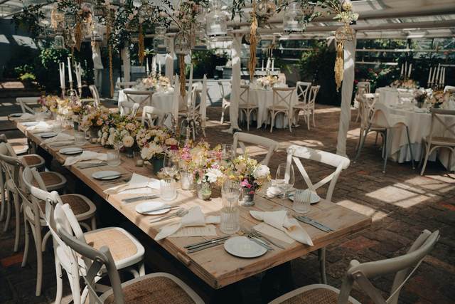 Lange gedekte tafels met bloemen voor een trouwfeest