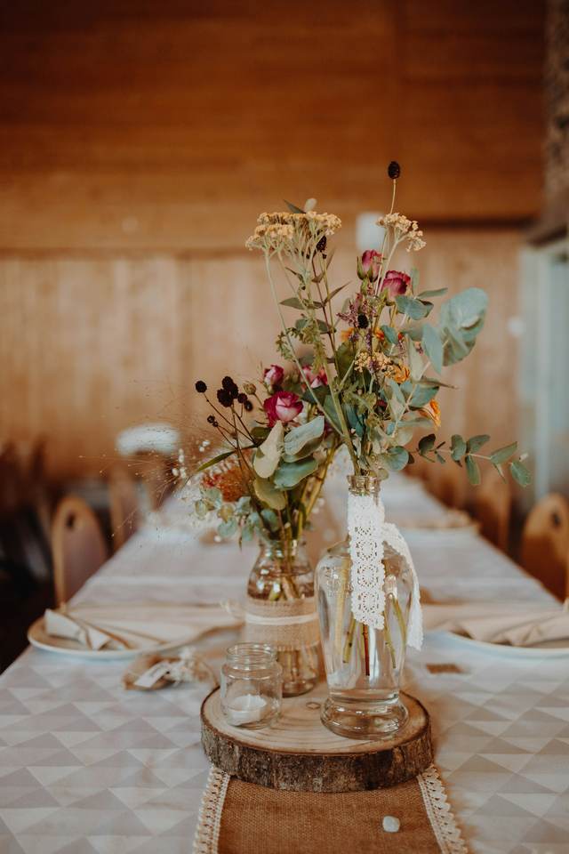 Veldbloemen op een lange feesttafel met witte tafelloper
